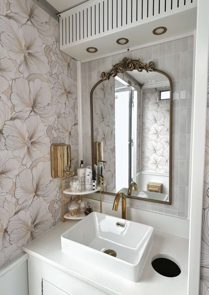 Bright luxury restroom trailer vanity with mirror and gold fixtures
