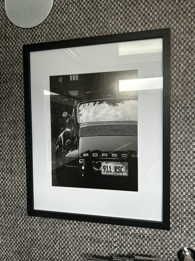 Homepage 13 Black and white Porsche wall art inside the men's washroom of a Toiluxe luxury mobile restroom trailer for upscale outdoor events.