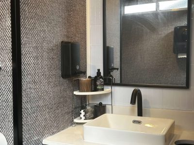 Dark vanity and mirror design inside a luxury restroom trailer bathroom