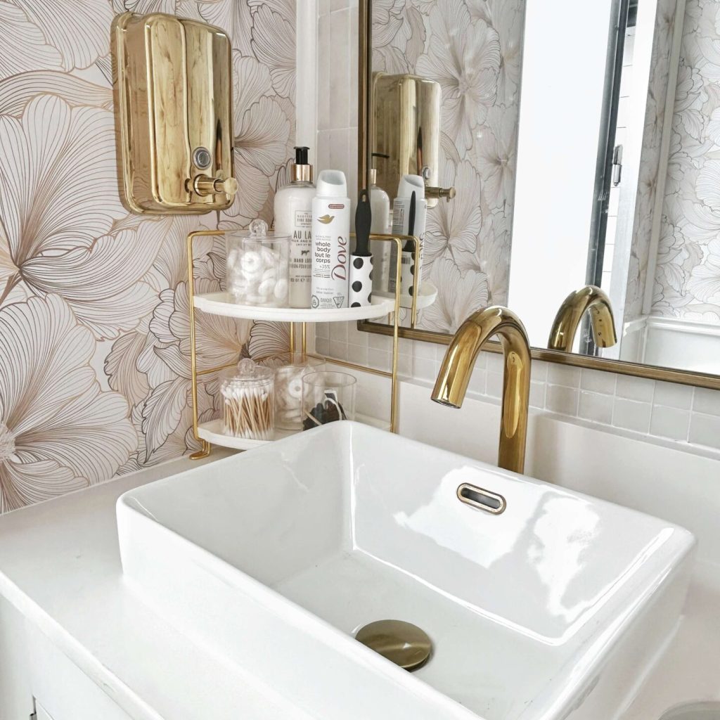 Luxury restroom trailer sink with gold faucet and marble style wall finish