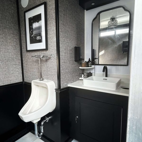 Urinal and sink area inside men's side of luxury restroom trailer