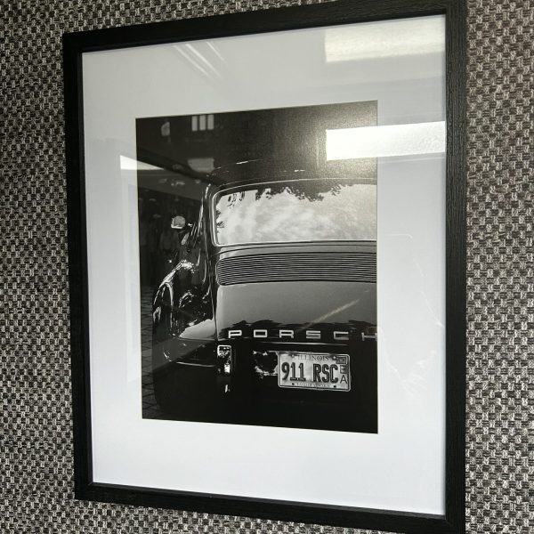 Homepage 45 Black and white Porsche wall art inside the men's washroom of a Toiluxe luxury mobile restroom trailer for upscale outdoor events.
